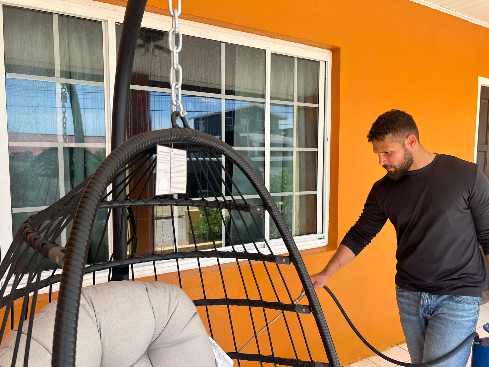 Pest control technician with spray hose on residential patio